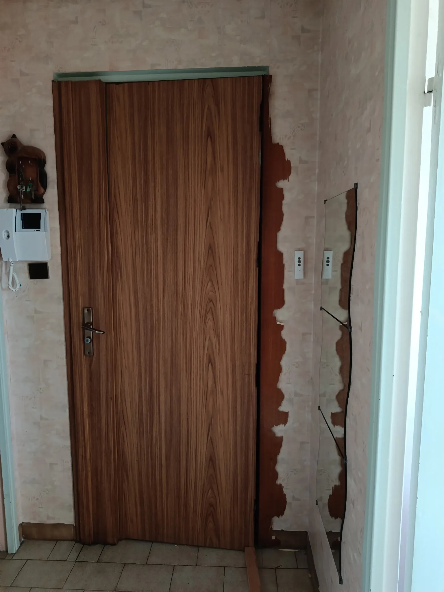 Porte intérieure en bois avec serrure, installée dans un intérieur en cours de rénovation.