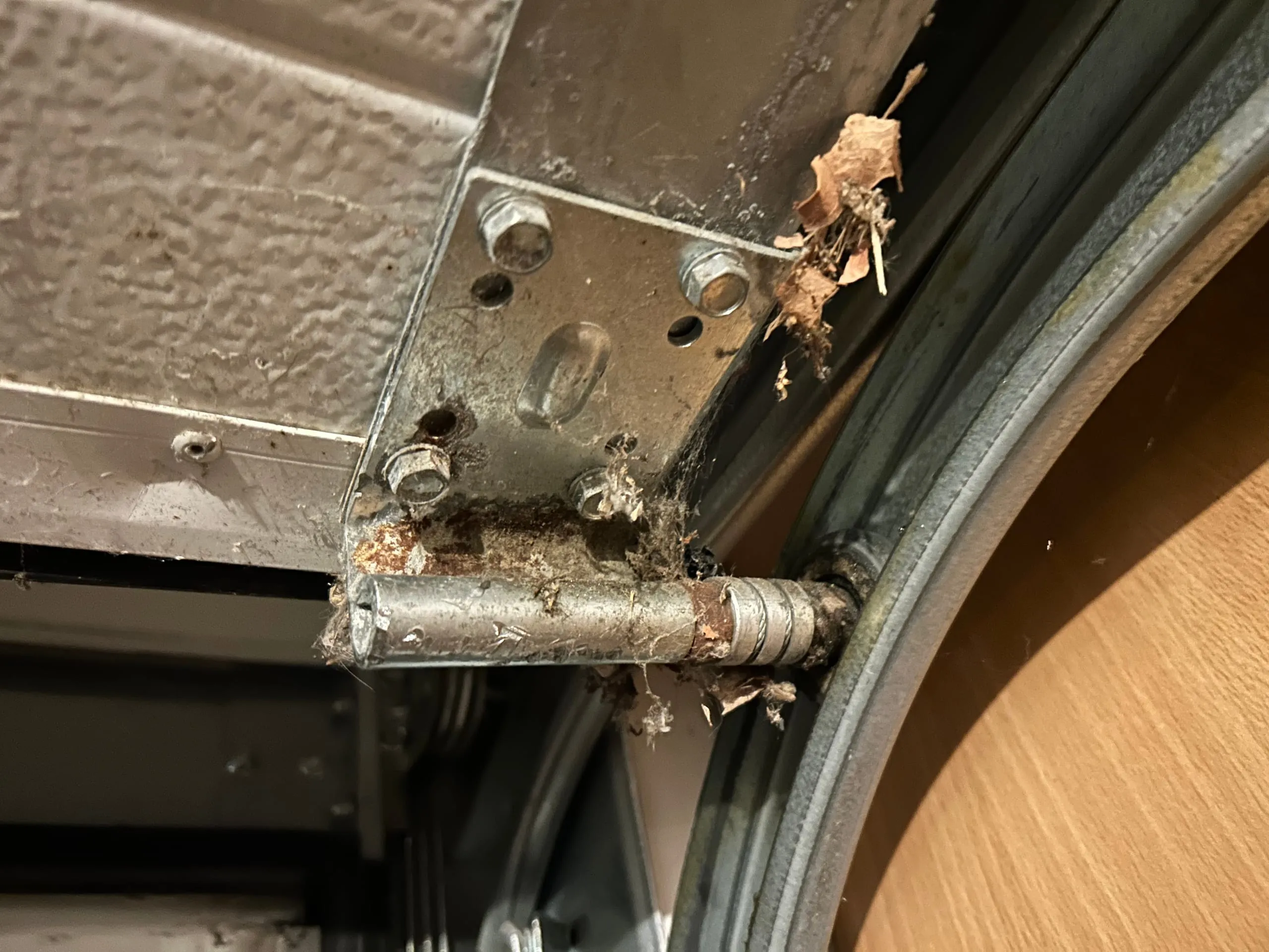 Charnière métallique rouillée et endommagée sur une porte.