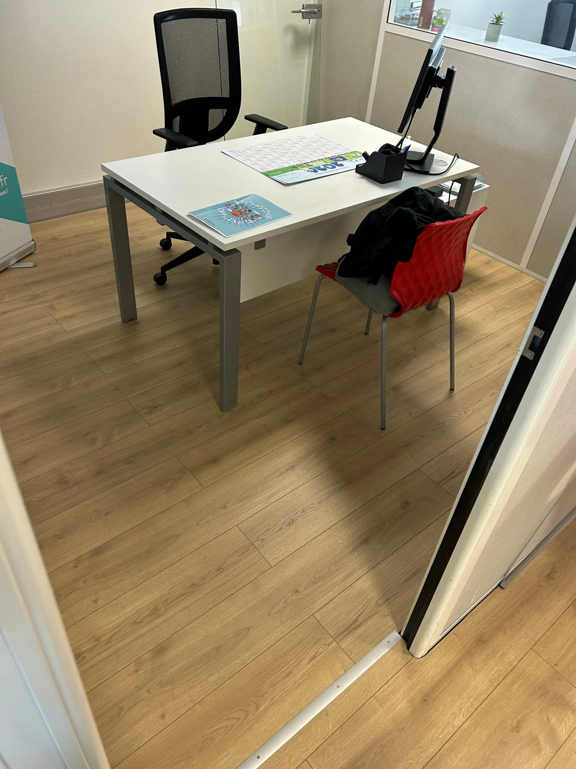 Bureau équipé d’un parquet flottant bois autour du mobilier de travail.