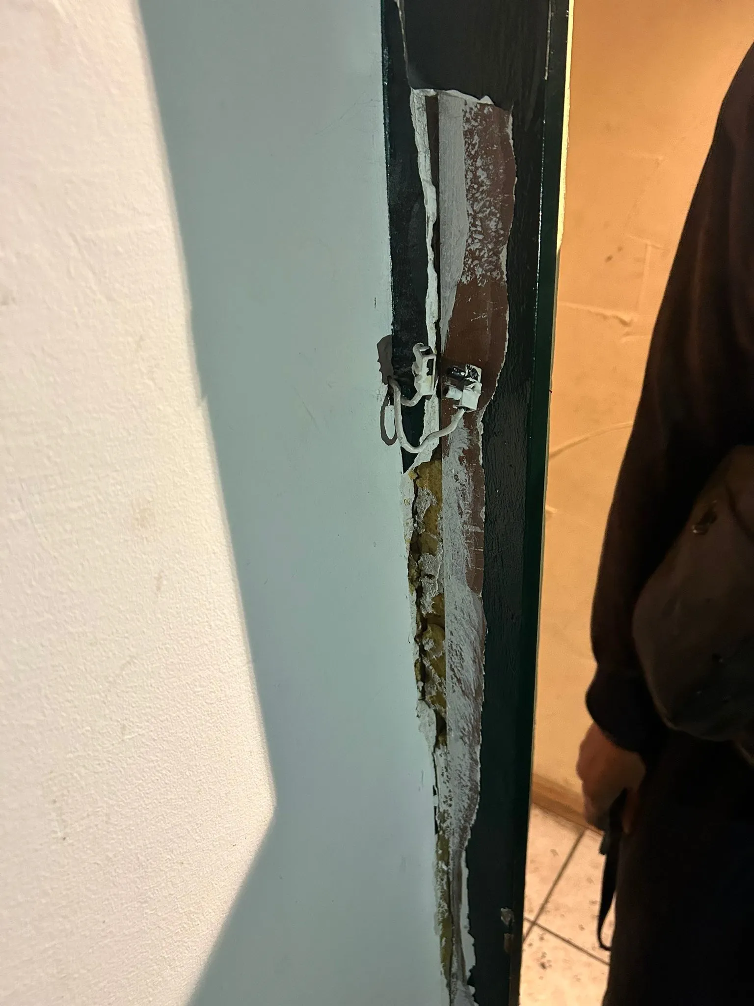 Encadrement peint en vert arraché et découvert après une effraction.