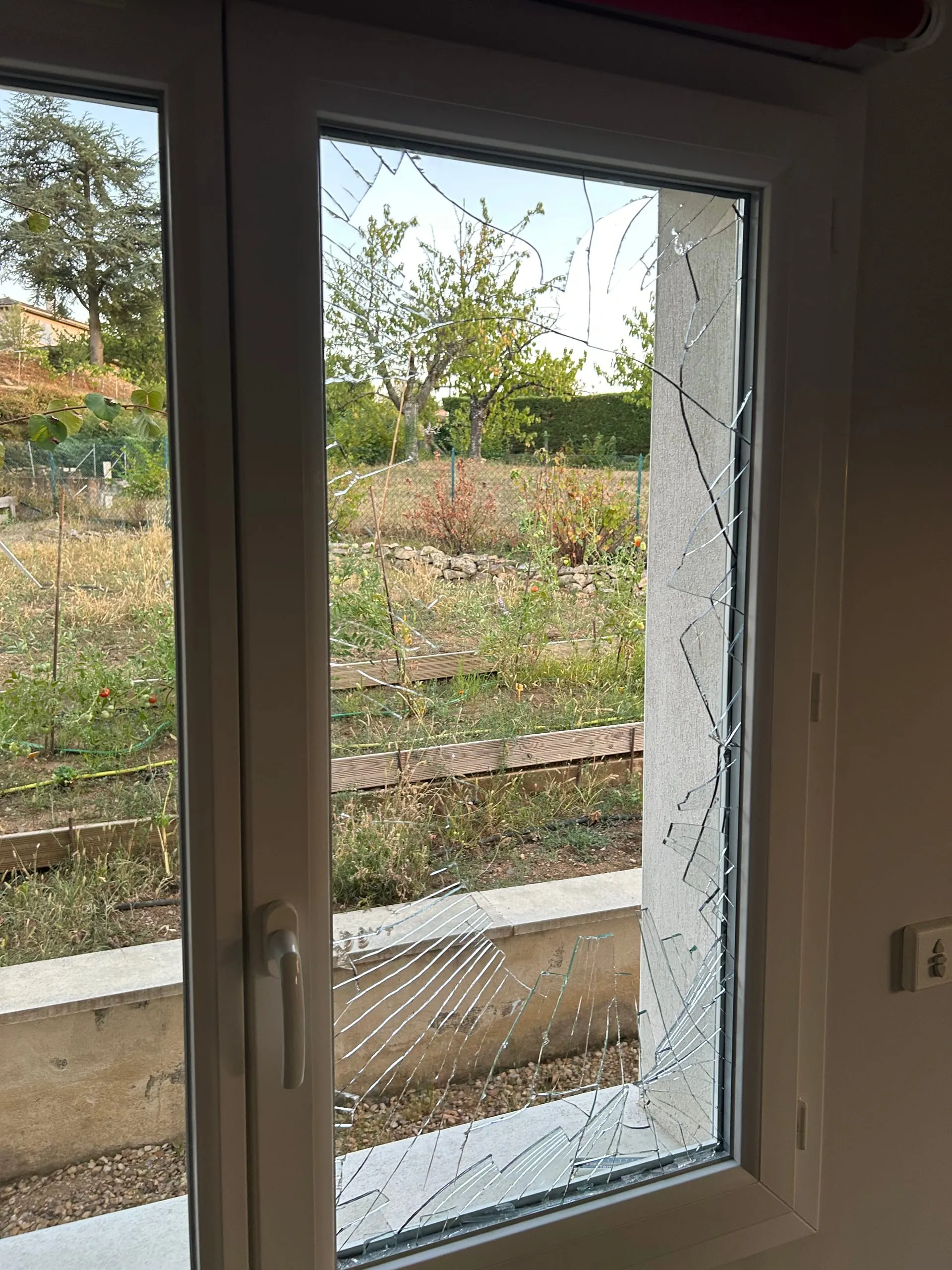 Double vitrage fortement brisé dans un ouvrant PVC blanc après une effraction.