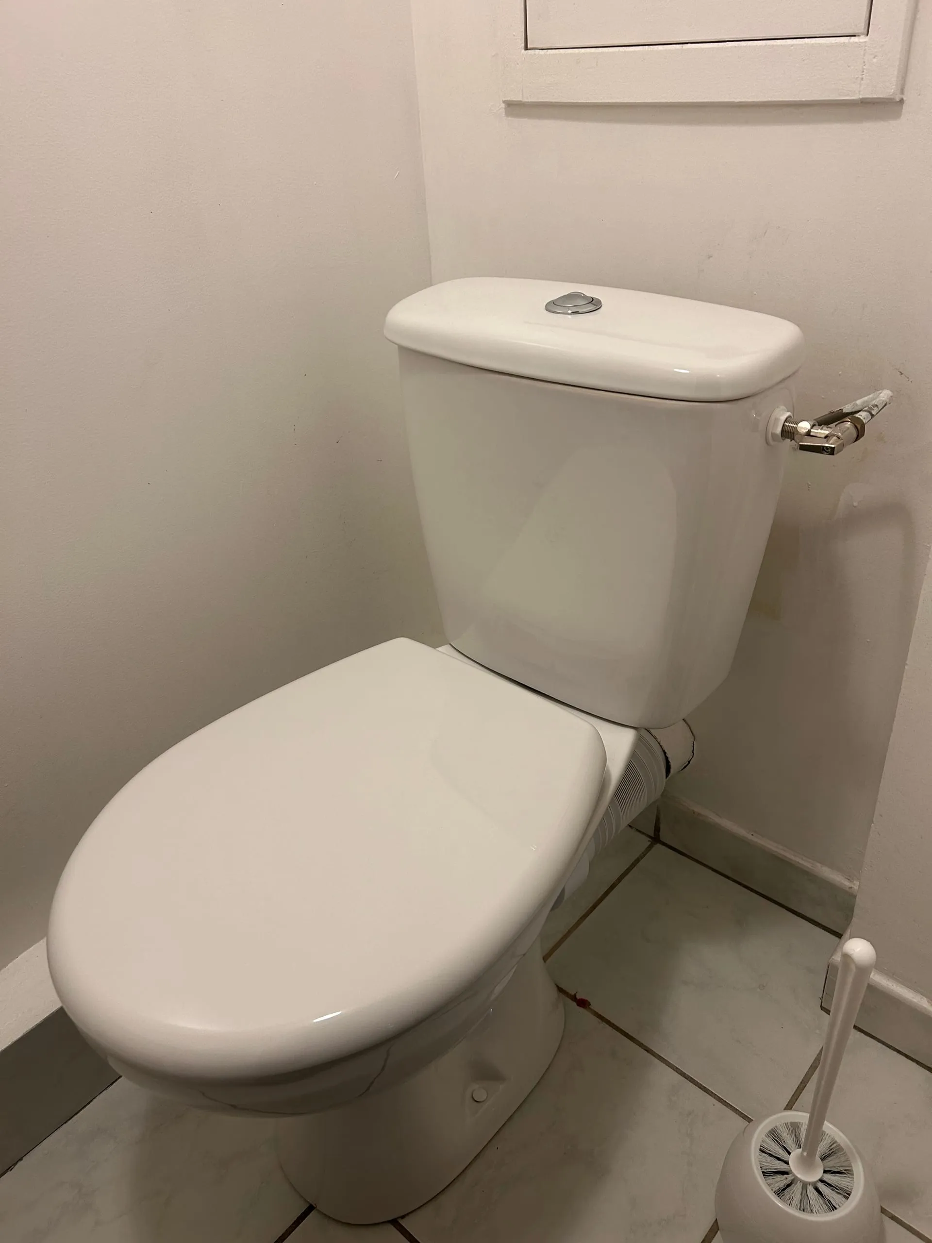 Nouveau WC blanc installé dans une petite pièce carrelée.
