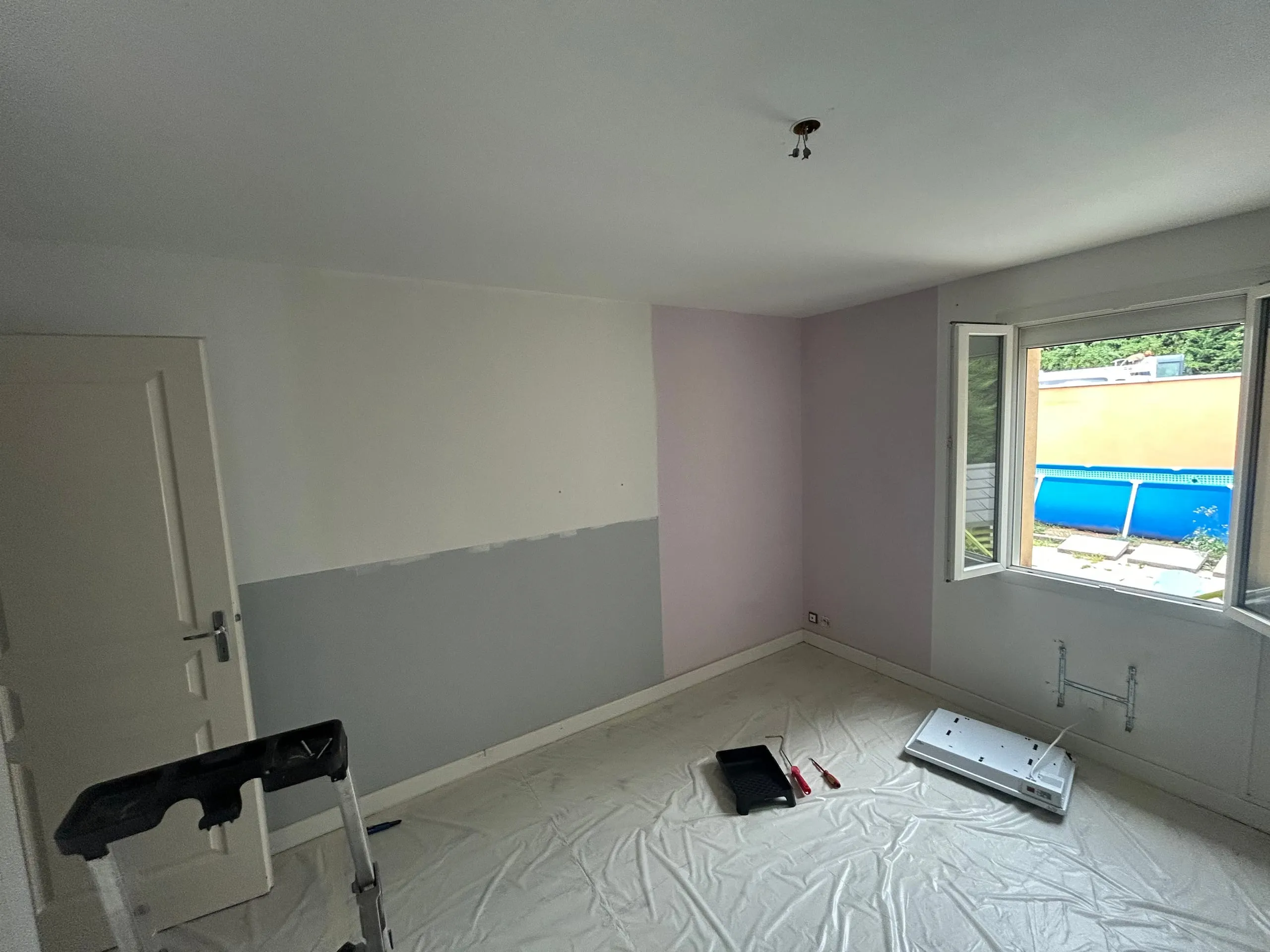 Murs de chambre peints en blanc après travaux.