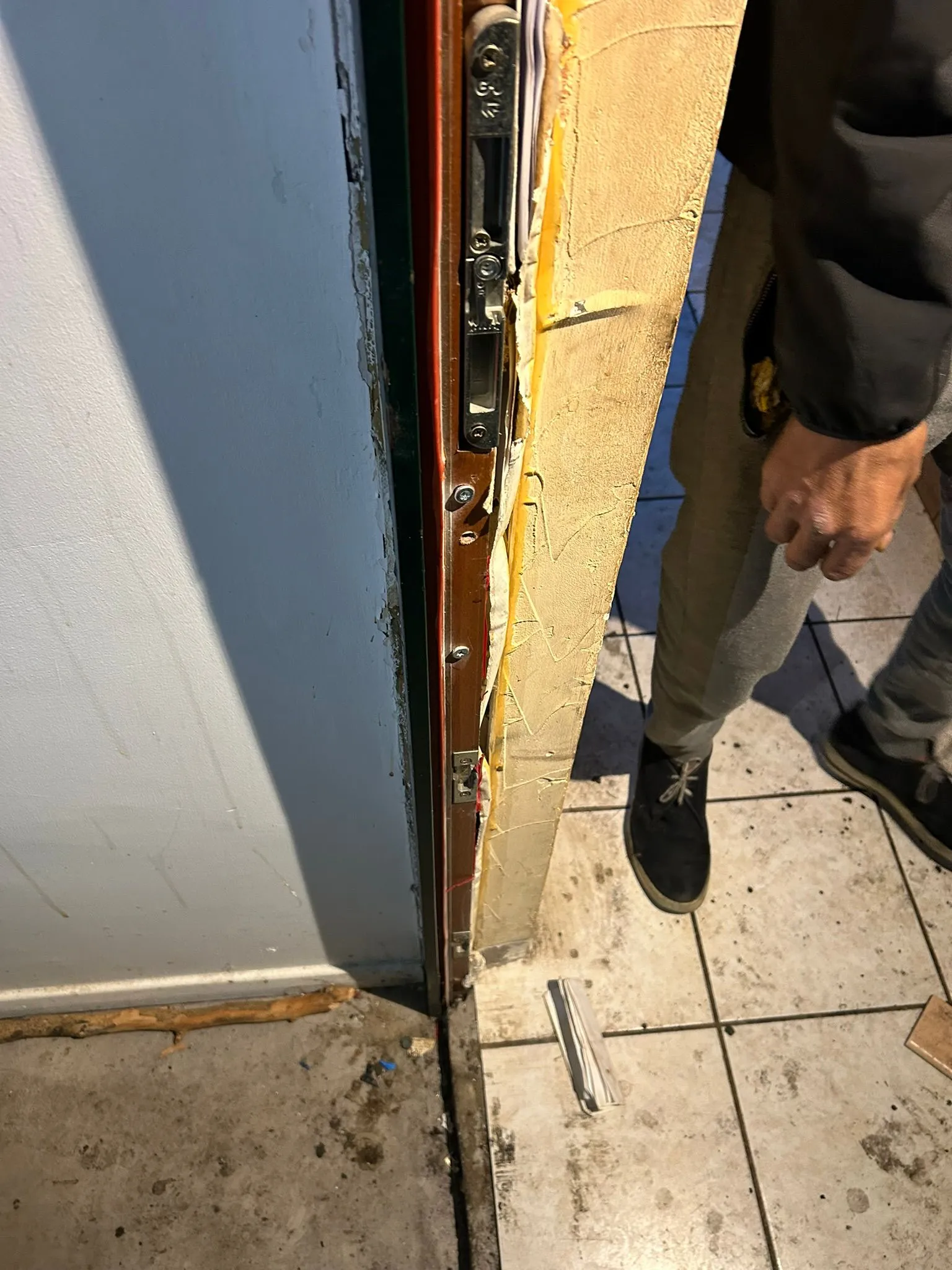 Montant d’une porte en bois endommagé autour des points de fermeture.